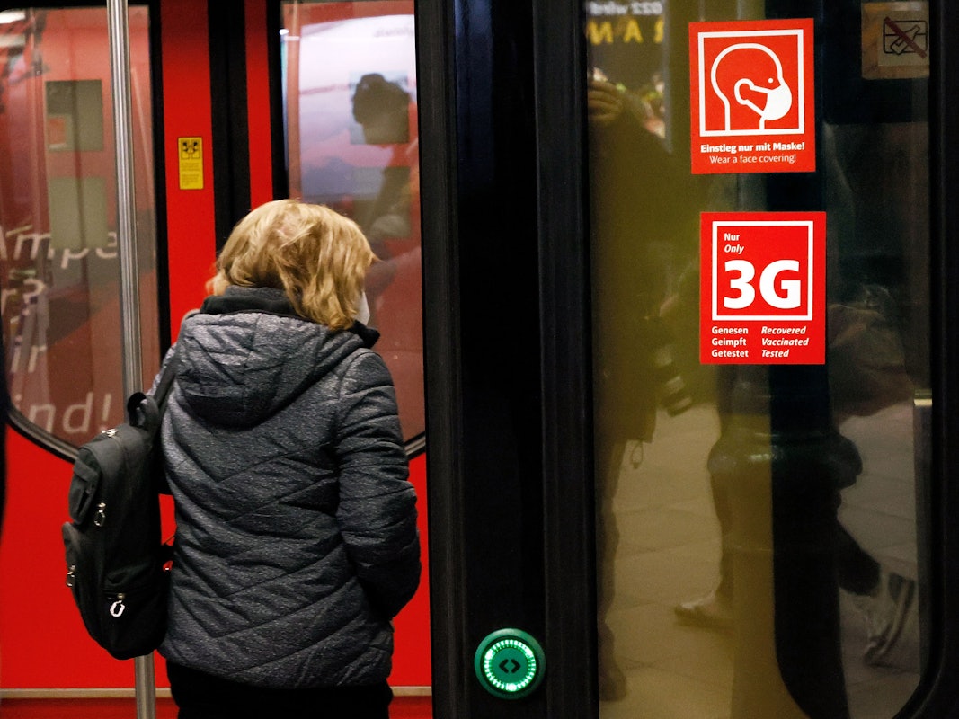 Ein Fahrgast betritt im Januar eine Bahn in Berlin, an der Schildern mit dem Hinweis auf die Masken- und 3-G-Regeln zu sehen sind. Die Maskenpflicht soll nun doch ausgeweitet werden.