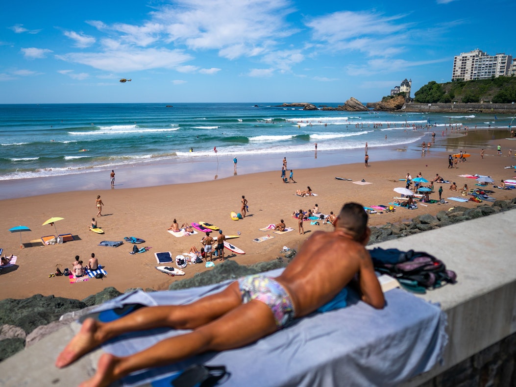 Urlauber entspannen am Strand von Biarritz in Frankreich.
