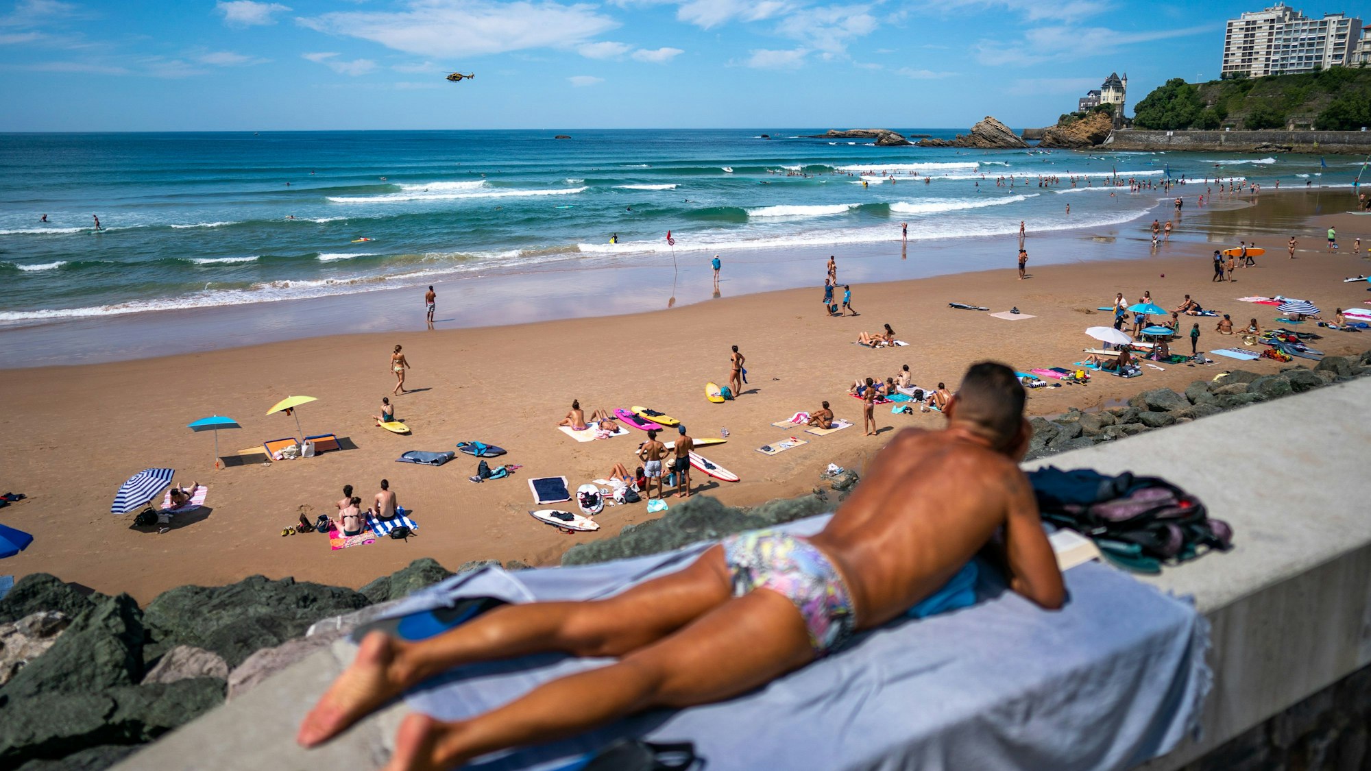 Urlauber entspannen am Strand von Biarritz in Frankreich.