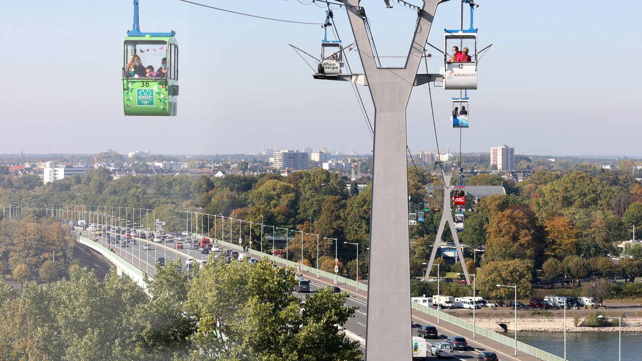 Gondeln der Kölner Seilbahn fahren über die Stadt.