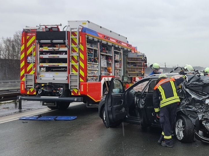 Ein zerfetztes Auto steht auf der Autobahn, mehrere Einsatzkräfte sind im Einsatz.