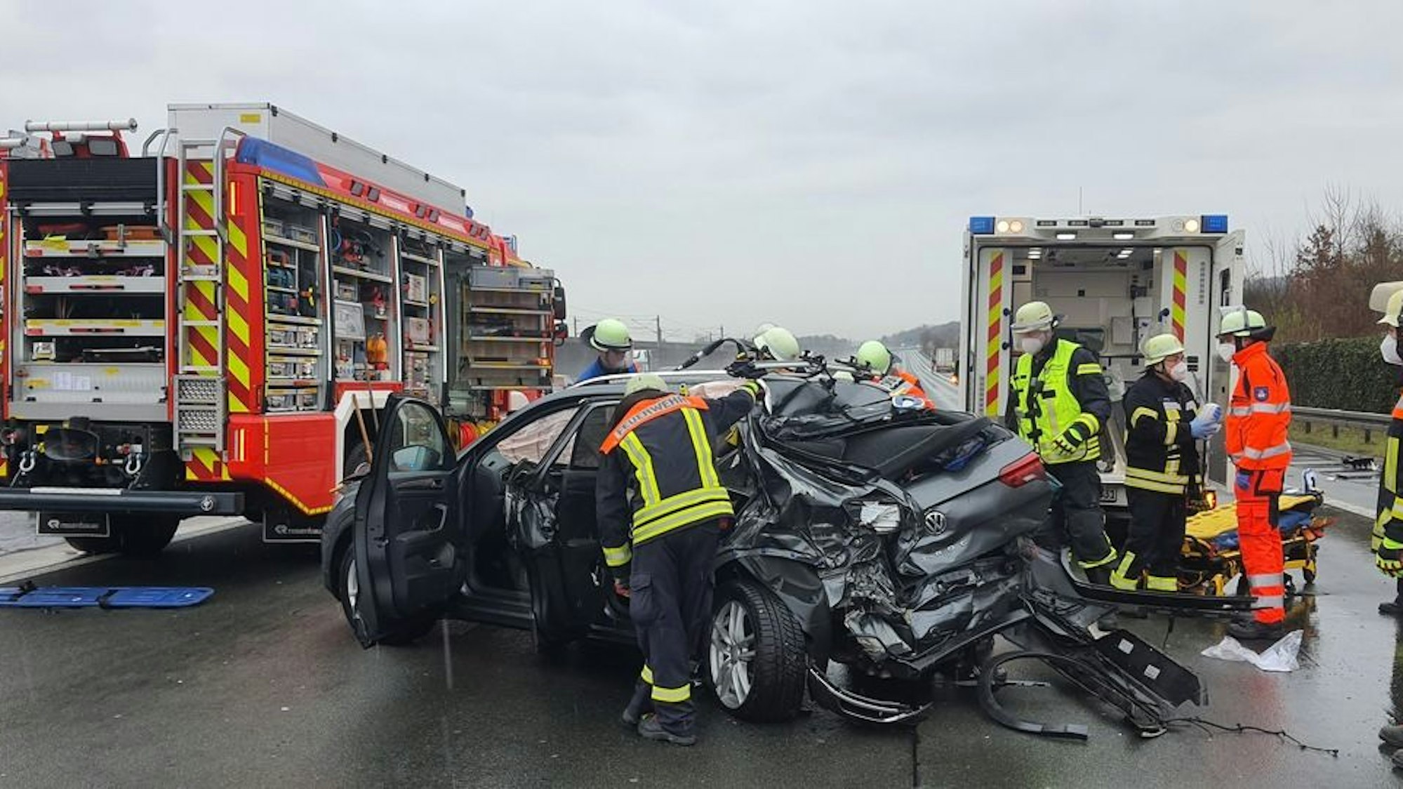 Ein zerfetztes Auto steht auf der Autobahn, mehrere Einsatzkräfte sind im Einsatz.