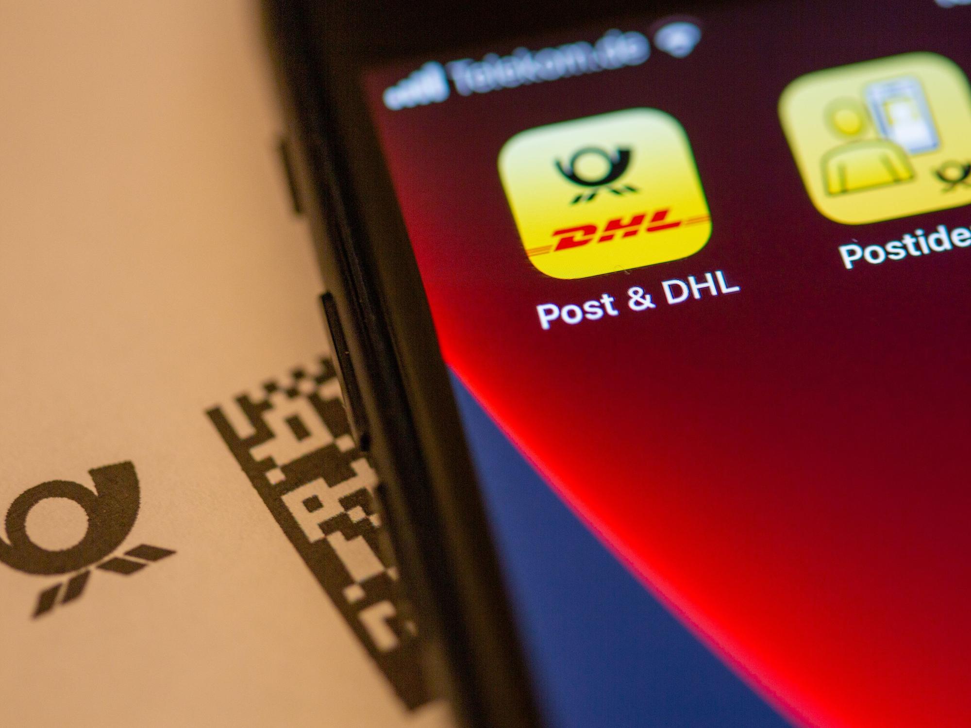 Das Logo der „Post & DHL“-App ist auf dem Display eines Smartphones zu sehen.