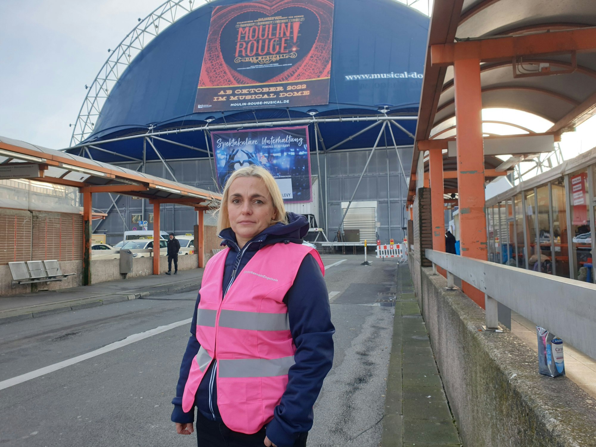 Inga Weber steht vor dem Musical Dome am Breslauer Platz und neben der neuen Anlaufstelle für Geflüchtete aus der Ukraine.
