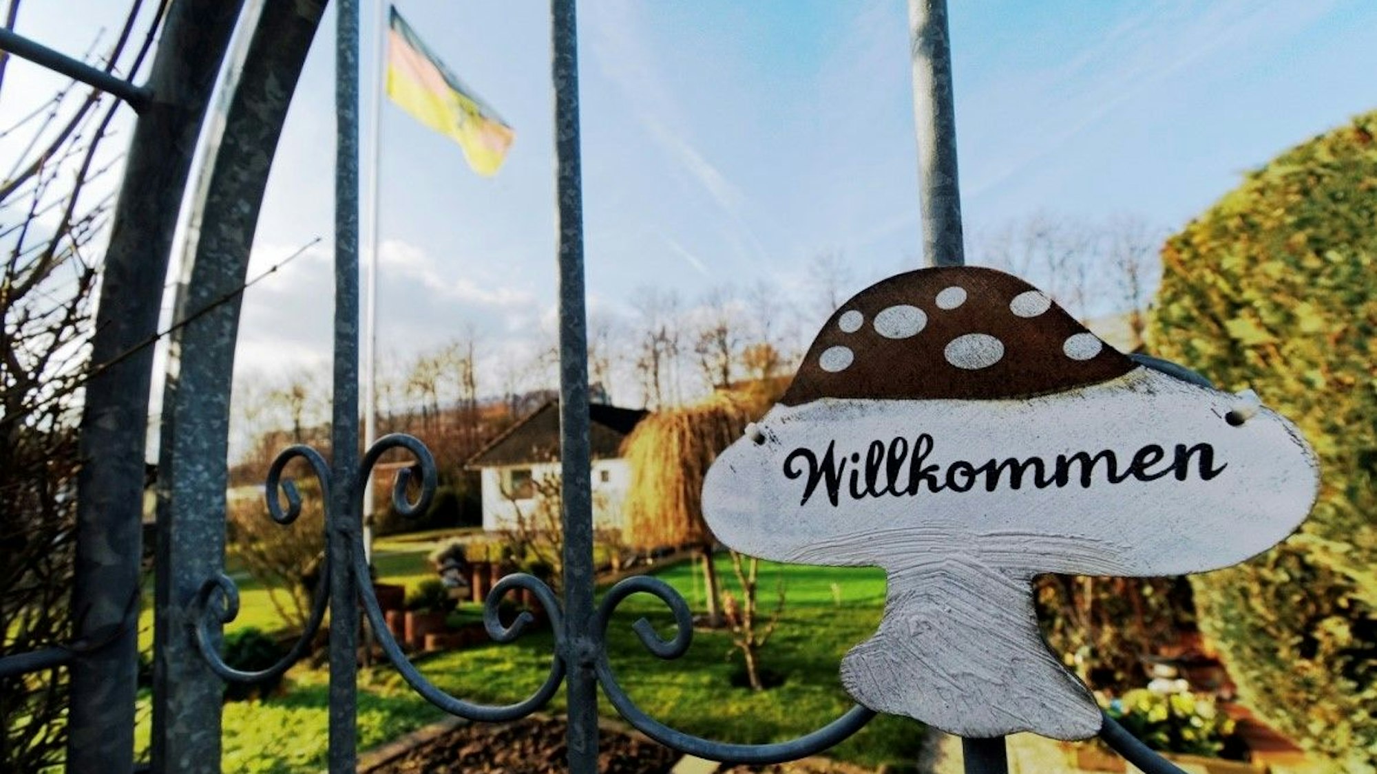 Ein Schild mit dem Schriftzug „Willkommen“ hängt am Tor eines Schrebergartens in einer Kleingartenanlage in Köln.