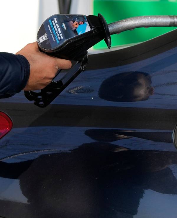 Ein Mann nimmt nach dem Tanken die Zapfpistole aus seinem Wagen. Die Preise für Benzin und Diesel haben durch den Krieg in der Ukraine neue Höchststände erreicht.