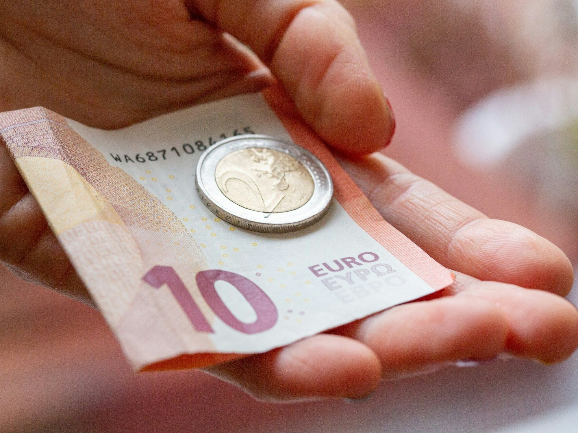 Eine Person hält in unserem Symbolbild Geld in der Hand: Die Ampel verdoppelt den Heizkostenzuschuss für viele Menschen.