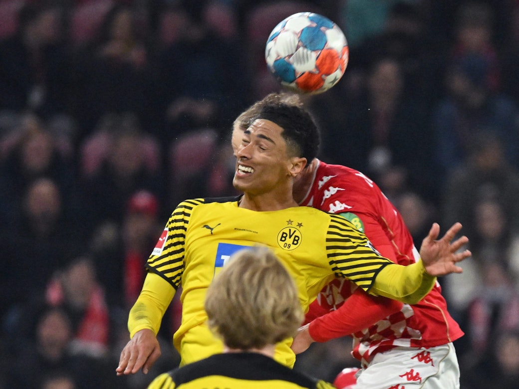 Der Mainzer Niklas Tauer (verdeckt) und Dortmunds Jude Bellingham kämpfen um den Ball.