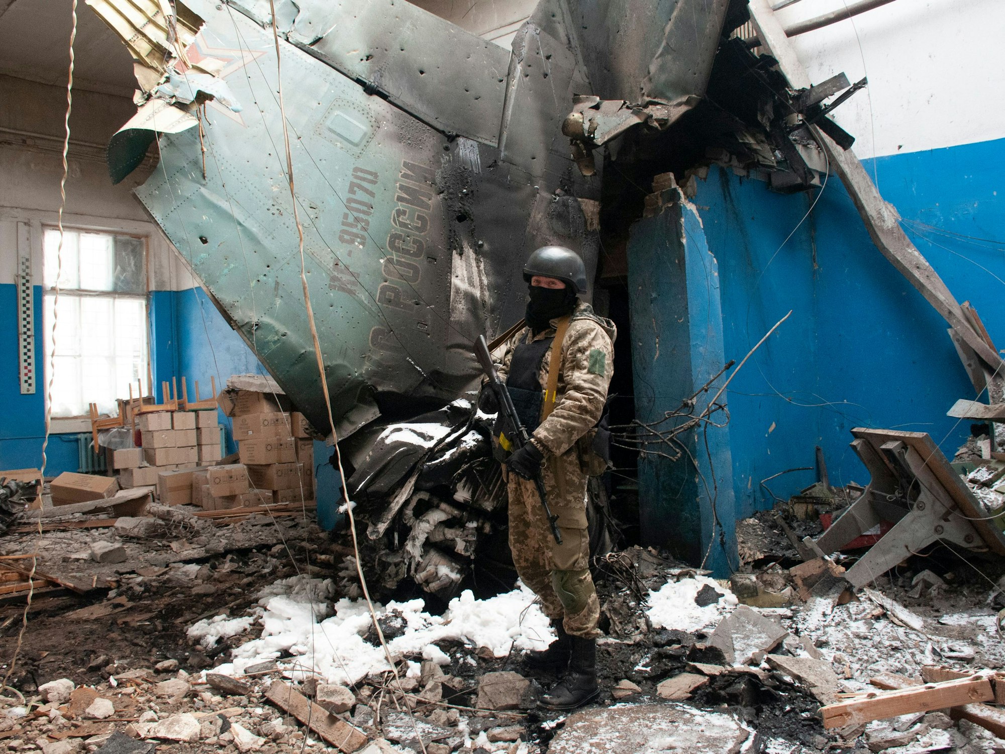 Ein ukrainischer Soldat steht am 8. März in Charkiw neben dem Seitenleitwerk eines abgestürzten russischen Su-34-Bombers. Gegenüber CNN haben sich russische Piloten, die sich in Gefangenschaft befinden, klar gegen Putin positioniert.