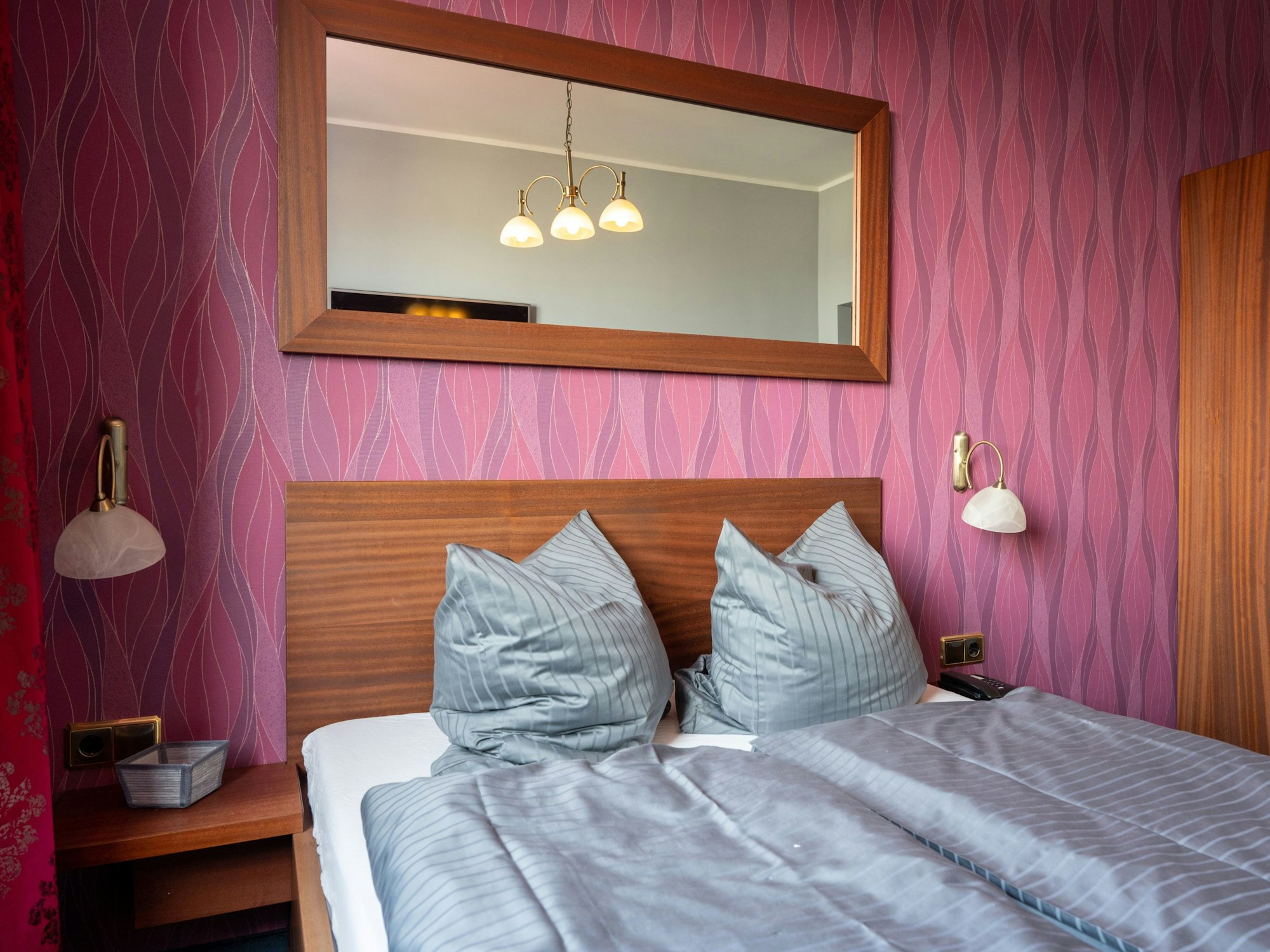 Blick auf ein Bett in einem Hotelzimmer.