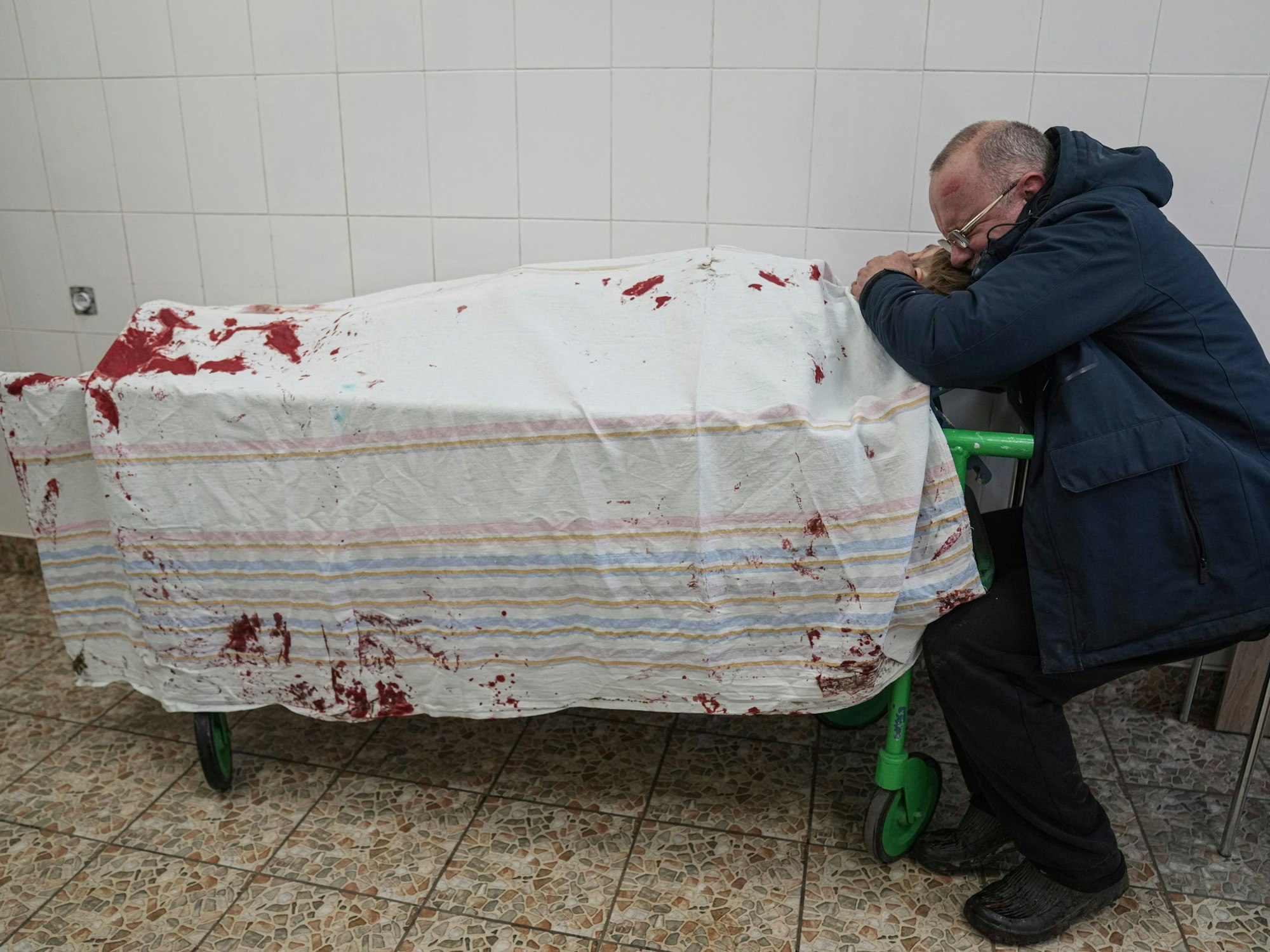 Ein Vater trauert am Totenbett seines Sohnes.