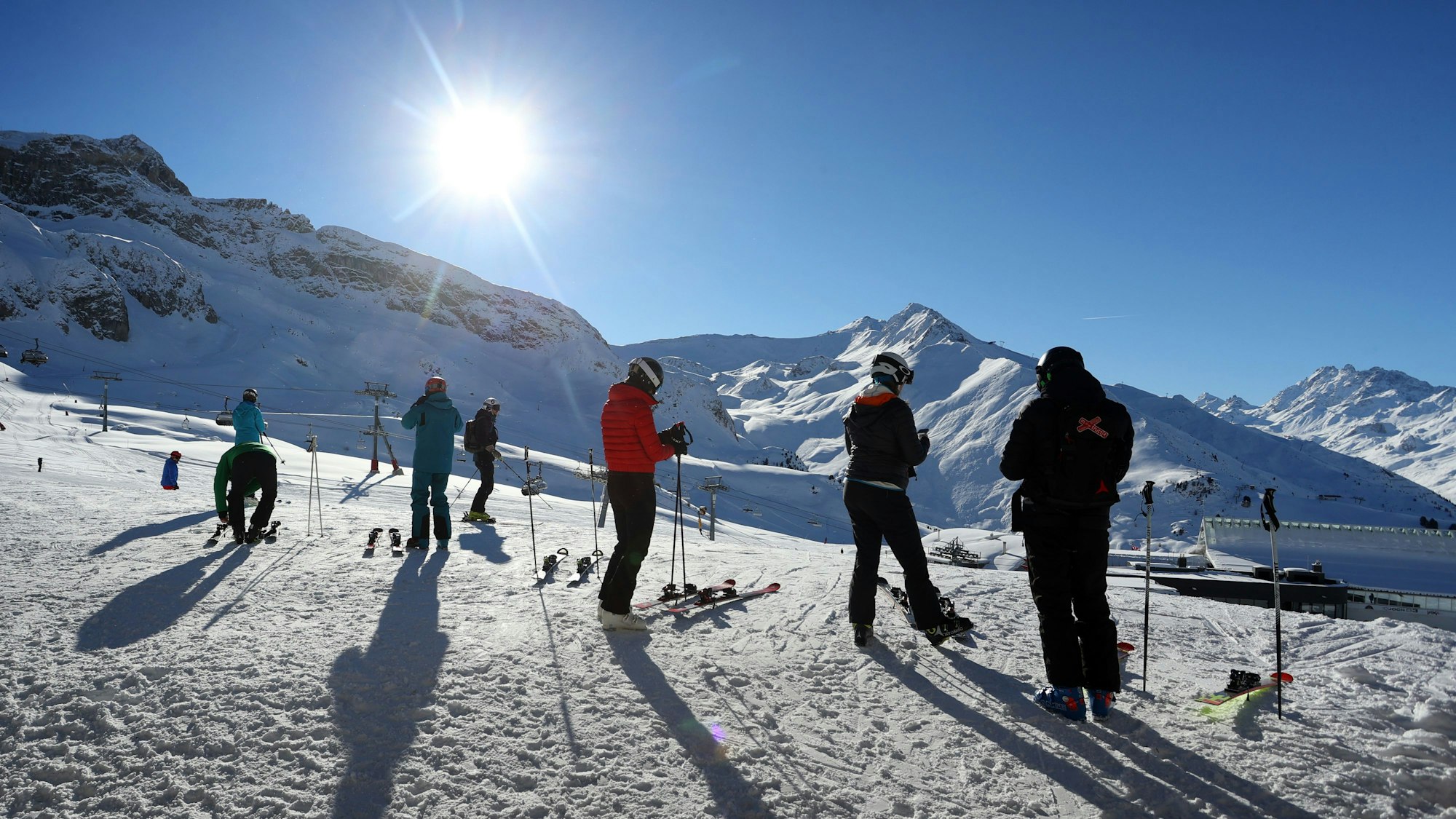 Wintersportler stehen im Skigebiet Ischgl im Sonnenschein.