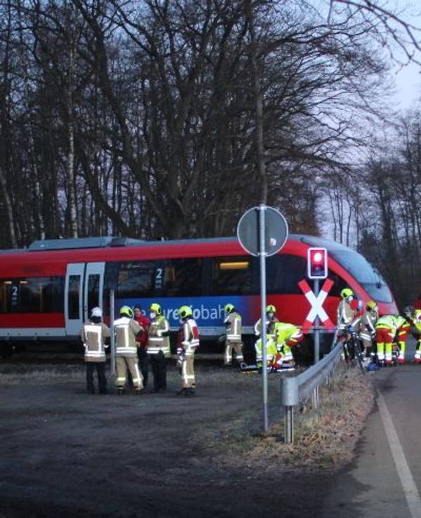Einsatzkräfte von Feuerwehr und Rettungsdienst befinden sich am Stolberger Bahnübergang auf der Steinbachstraße, wo ein Fahrradfahrer mit einem Zug kollidierte.