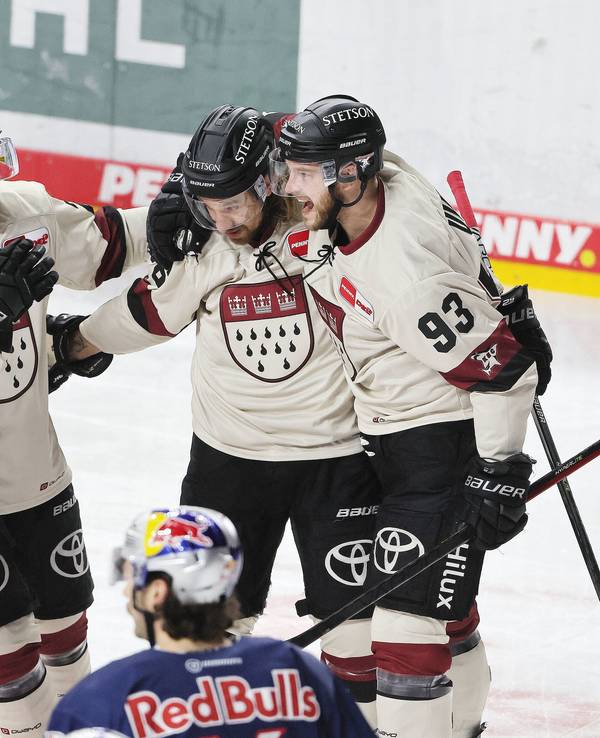 Die Haie jubeln mit Sebastian Uvira (rechts).