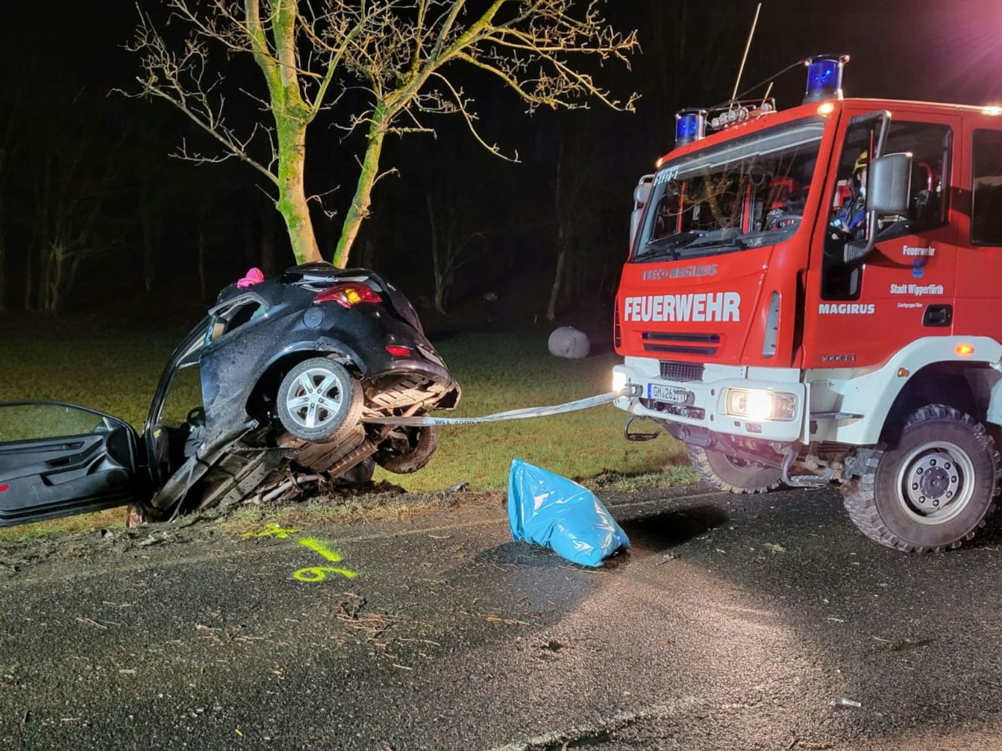 Einsatzkräfte der Feuerwehr ziehen das Fahrzeug aus dem Unfallbereich.