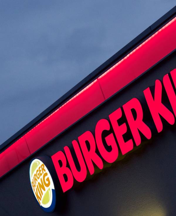 Der im Abendlicht erleuchtete Neon-Schriftzug einer Münchner Burger-King-Filiale.