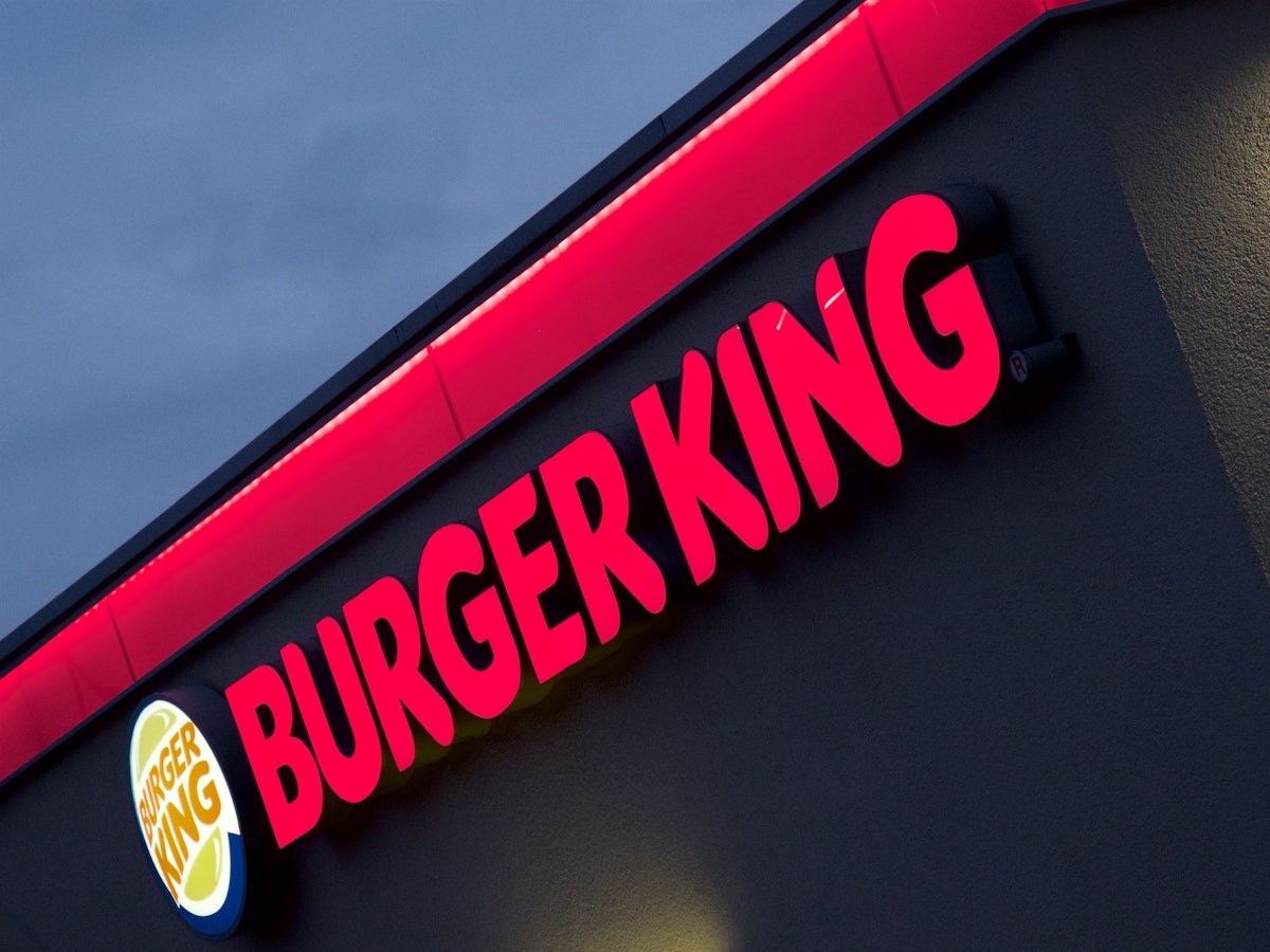 Der im Abendlicht erleuchtete Neon-Schriftzug einer Münchner Burger-King-Filiale.