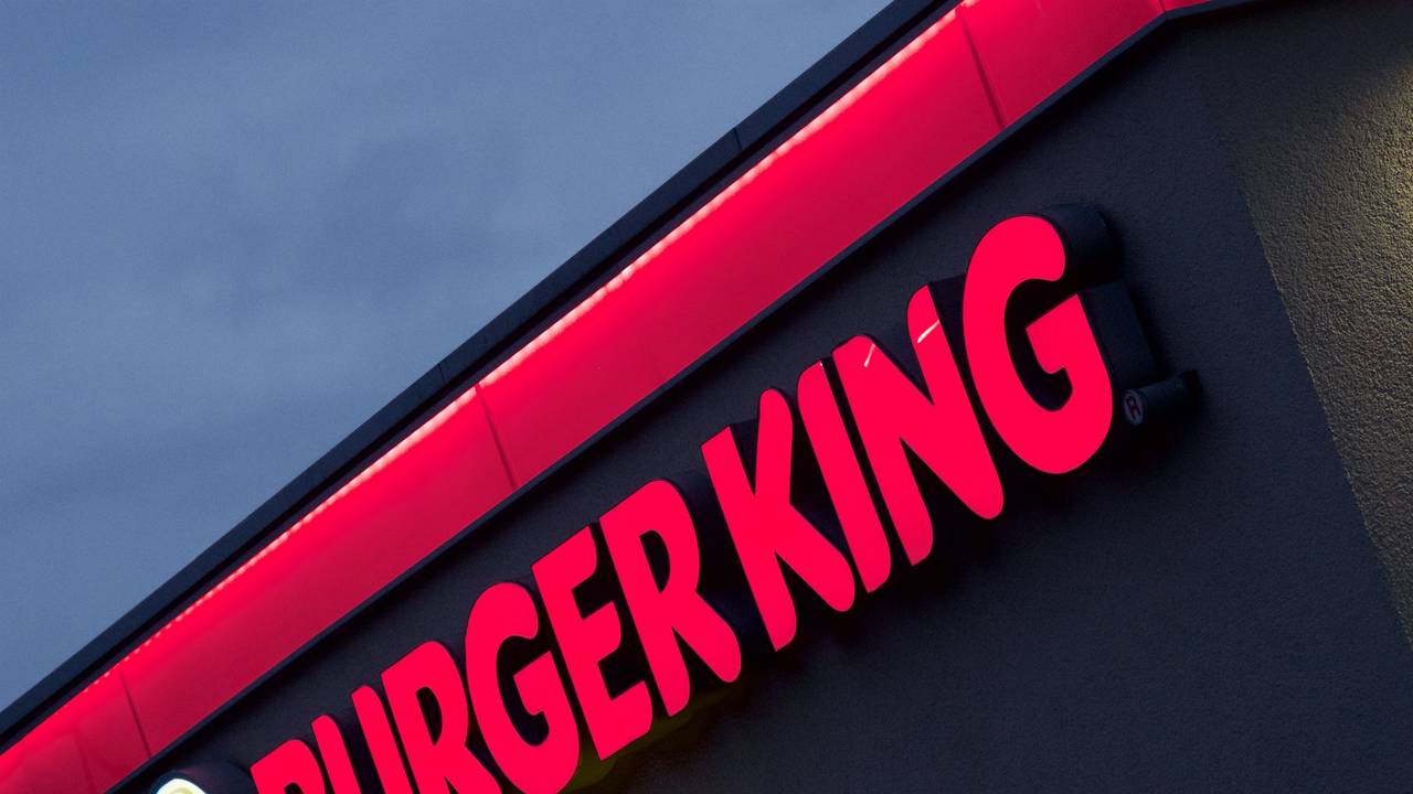 Der im Abendlicht erleuchtete Neon-Schriftzug einer Münchner Burger-King-Filiale.