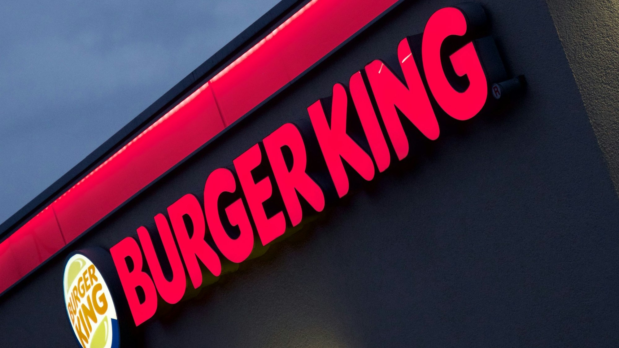 Der im Abendlicht erleuchtete Neon-Schriftzug einer Münchner Burger-King-Filiale.