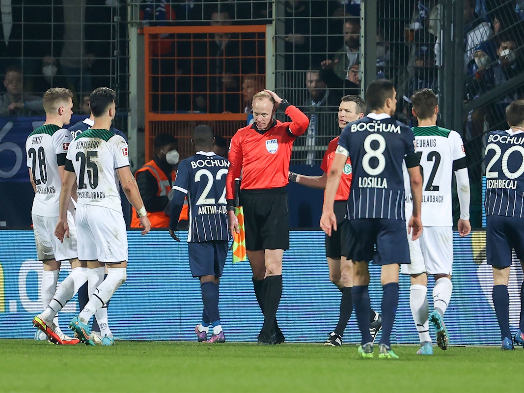 Der Linienrichter wurde von einem Becher getroffen und hält sich den Kopf.