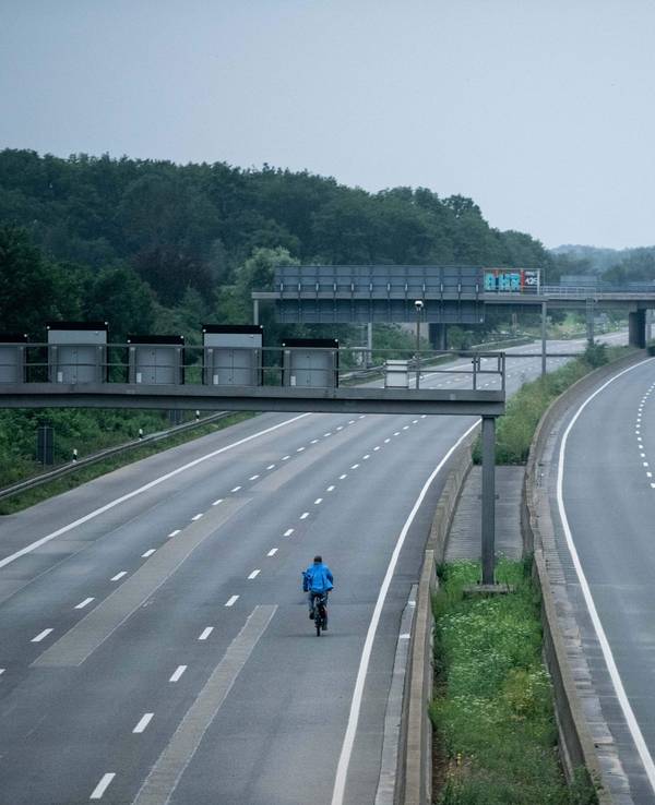 Ein Fahrradfahrer fährt über die gesperrte Autobahn A1 nahe Blessem in Erftstadt.