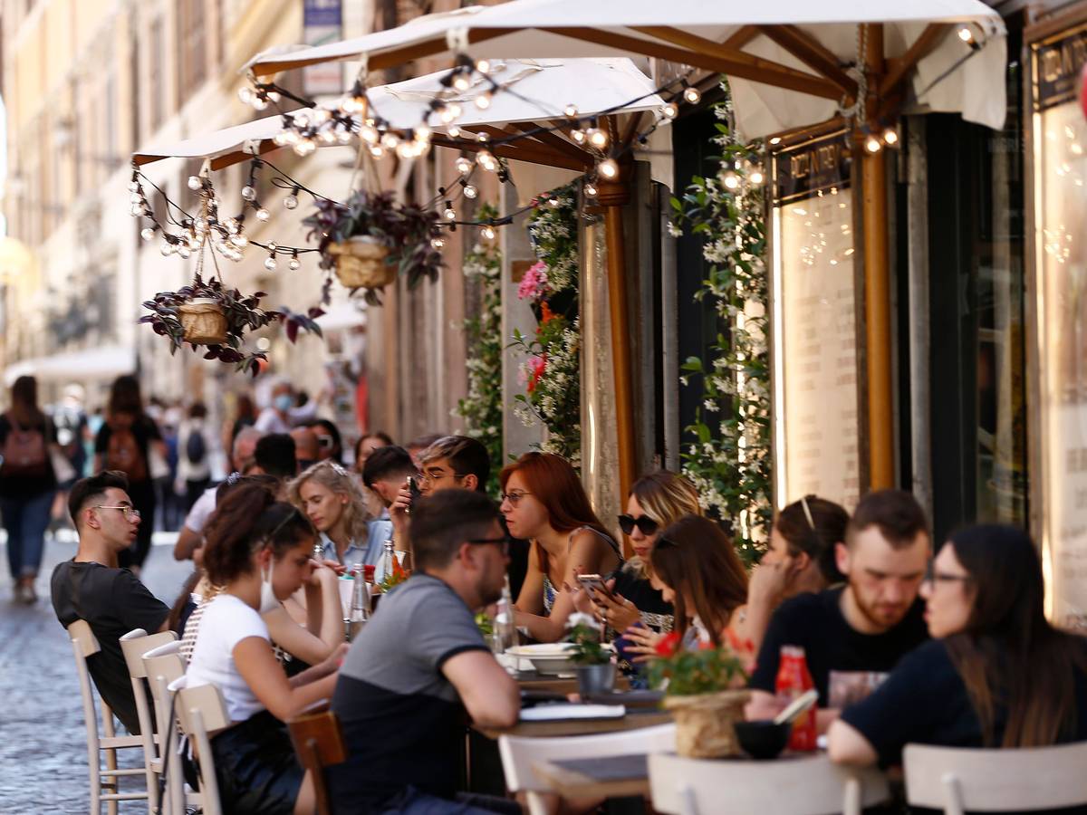 Touristen sitzen im Außenbereich eines Restaurants in der Via delle Muratte. In Rom hält der Tourismus nach und nach wieder Einkehr.