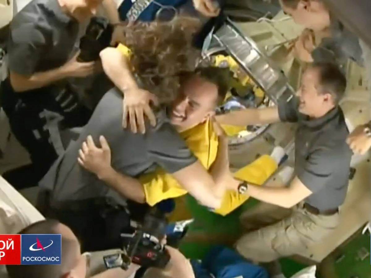 In diesem von Roskosmos zur Verfügung gestellten Video begrüßt die Besatzung der Internationalen Raumstation (ISS) drei russische Kosmonauten in gelber Kleidung, nachdem die Neuankömmlinge angedockt haben.