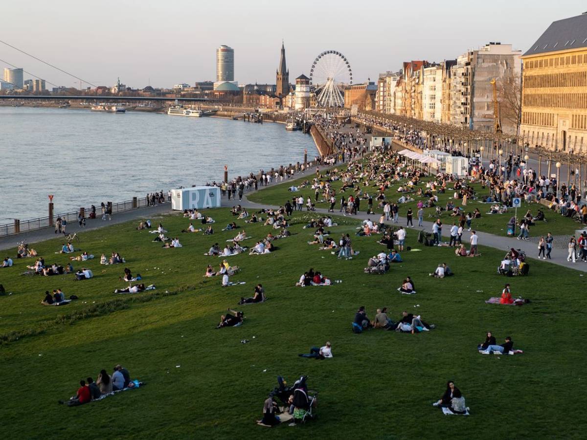 Menschen entspannen bei schönstem Wetter am Düsseldorfer Rheinufer. Auch die kommenden Wetter-Aussichten sind in NRW ein Grund zur Freude.