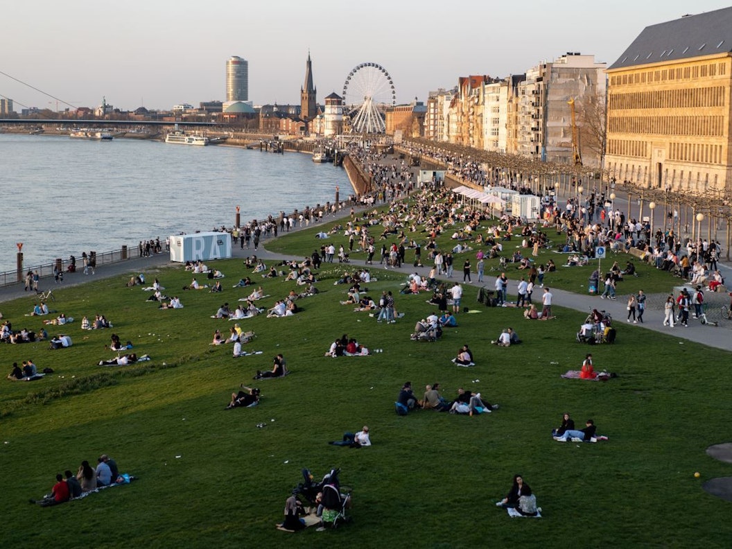 Menschen entspannen bei schönstem Wetter am Düsseldorfer Rheinufer. Auch die kommenden Wetter-Aussichten sind in NRW ein Grund zur Freude.