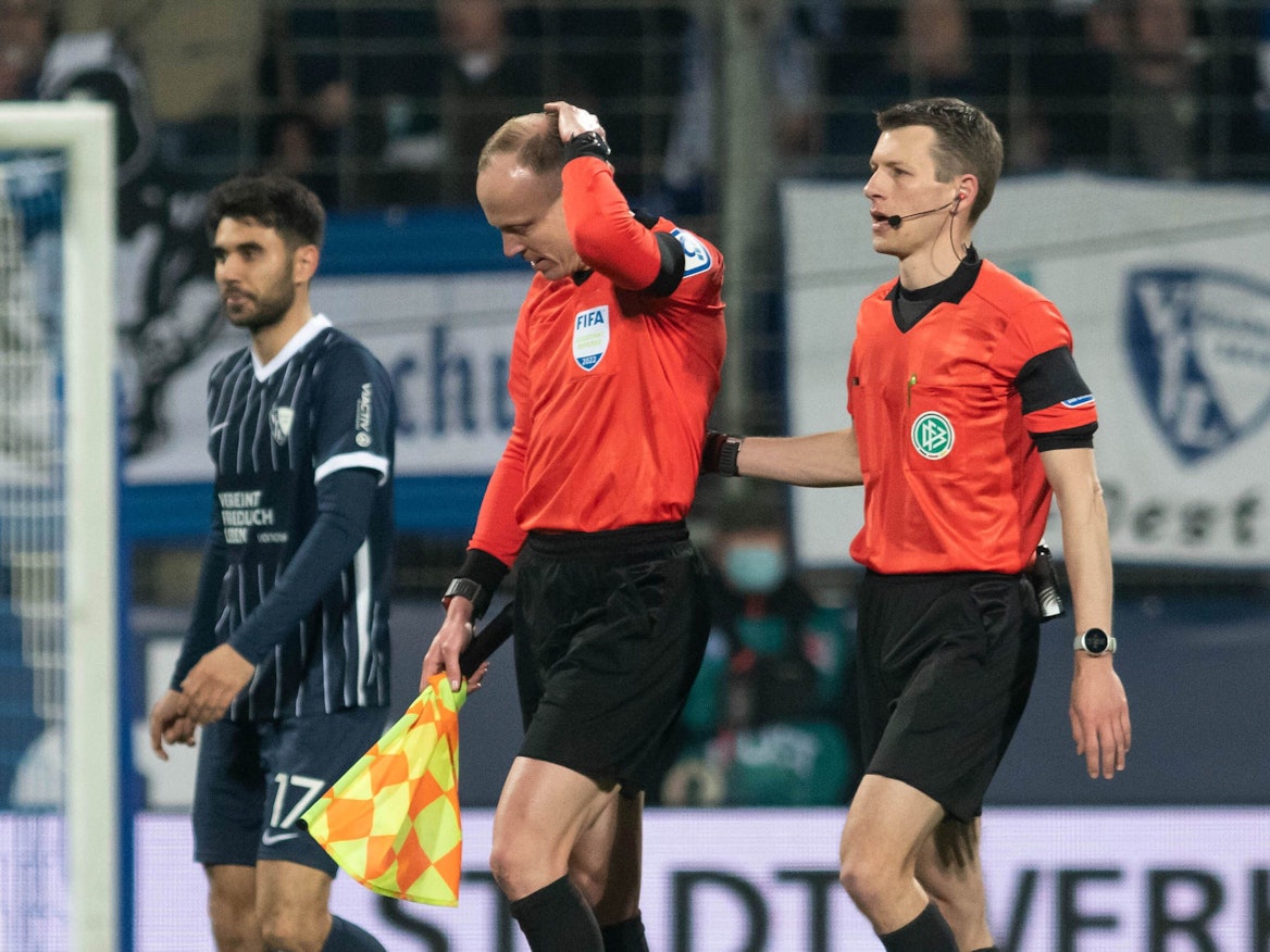 Das Schiedsrichtergespann um Benjamin Cortus (r.) verlässt während des Spiels das Spielfeld, nachdem Schiedsrichterassistent Christian Gittelmann einen Becher an den Kopf bekommen hatte.
