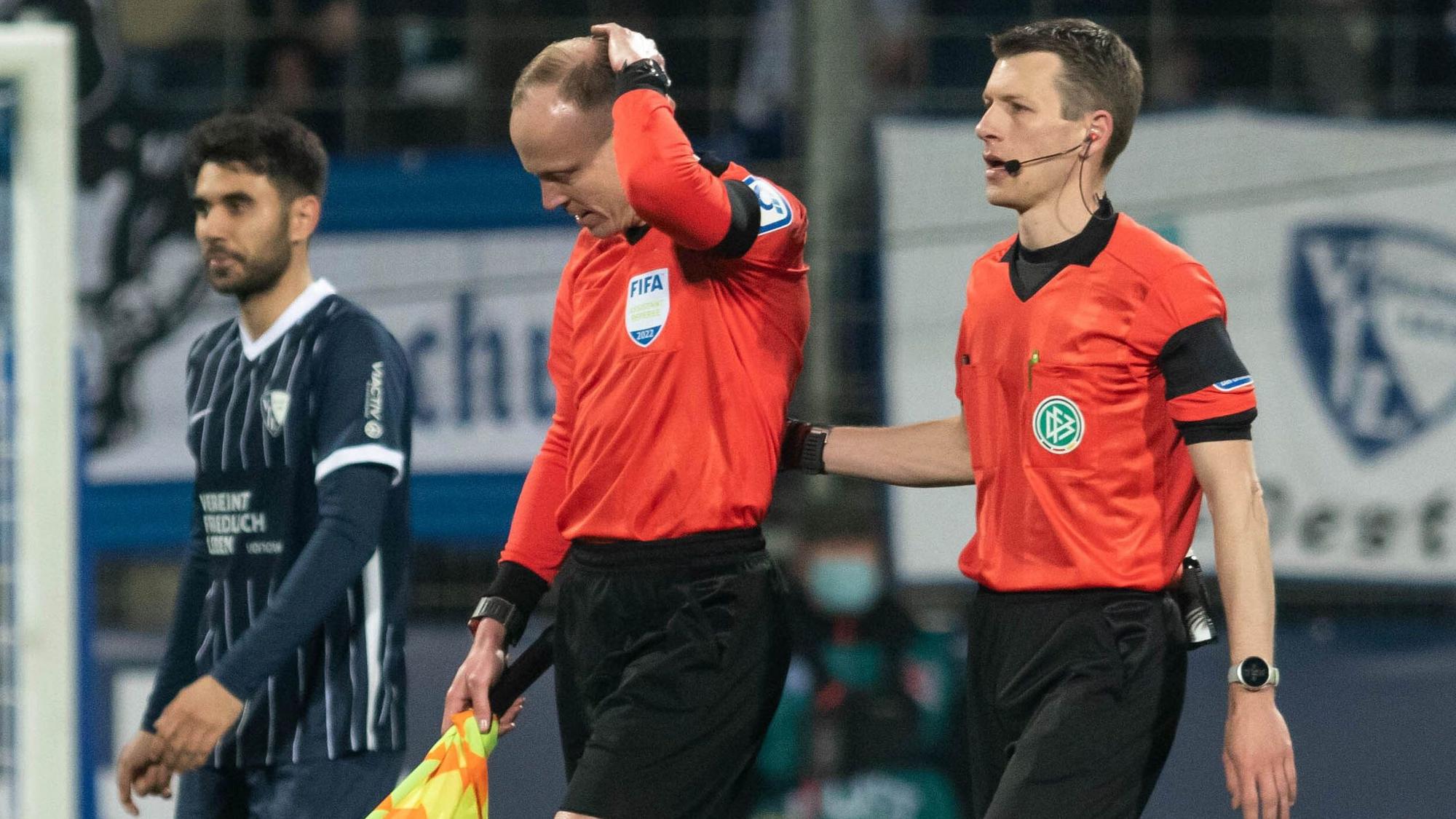 Das Schiedsrichtergespann um Benjamin Cortus (r.) verlässt während des Spiels das Spielfeld, nachdem Schiedsrichterassistent Christian Gittelmann einen Becher an den Kopf bekommen hatte.