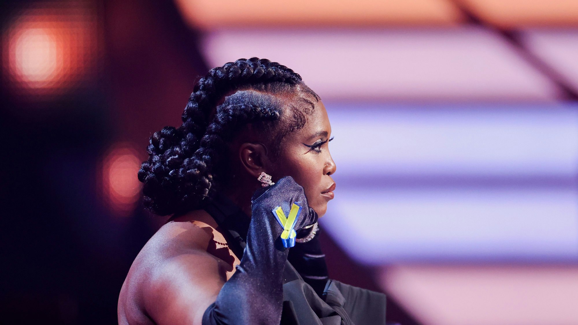 Motsi Mabuse, Jurymitglied, sitzt in der RTL-Tanzshow "Let's Dance" im Coloneum und trägt eine Schleife in de Farben der ukrainischen Flagge an der Hand.