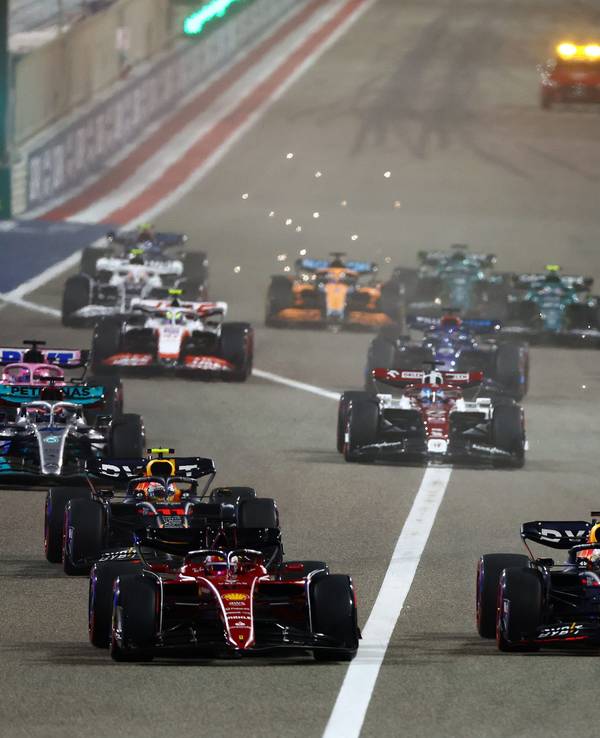 BAHRAIN, BAHRAIN - MARCH 20: Charles Leclerc of Monaco driving (16) the Ferrari F1-75 leads Max Verstappen of the Netherlands driving the (1) Oracle Red Bull Racing RB18 and the rest of the field going into the first corner at the start of the race during the F1 Grand Prix of Bahrain at Bahrain International Circuit on March 20, 2022 in Bahrain, Bahrain. (Photo by Mark Thompson/Getty Images)