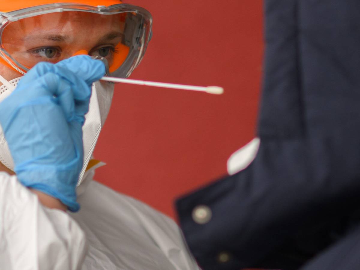 Ein Mitarbeiter nimmt einen Abstrich von einer Patientin für einen PCR-Test auf das Coronavirus vor einer Arztpraxis in der Region Hannover. Die bundesweite Sieben-Tage-Inzidenz stieg am Montag nach Angaben des Robert Koch-Instituts (RKI) wieder leicht an.