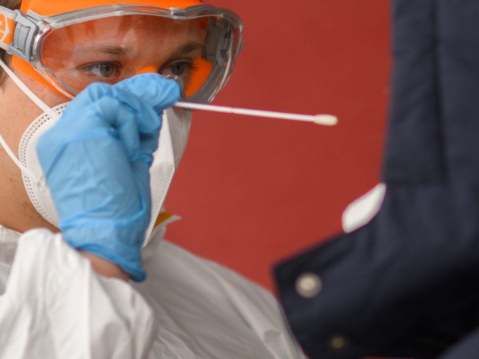 Ein Mitarbeiter nimmt einen Abstrich von einer Patientin für einen PCR-Test auf das Coronavirus vor einer Arztpraxis in der Region Hannover. Die bundesweite Sieben-Tage-Inzidenz stieg am Montag nach Angaben des Robert Koch-Instituts (RKI) wieder leicht an.