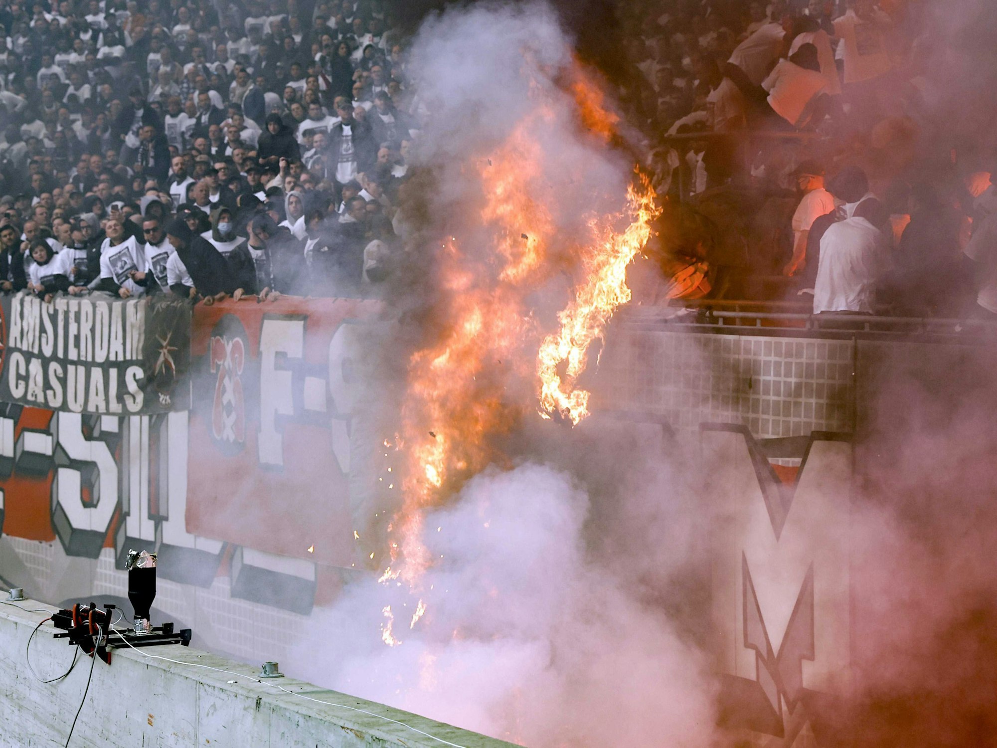 Ein Ajax-Banner fängt im Stadion Feuer.