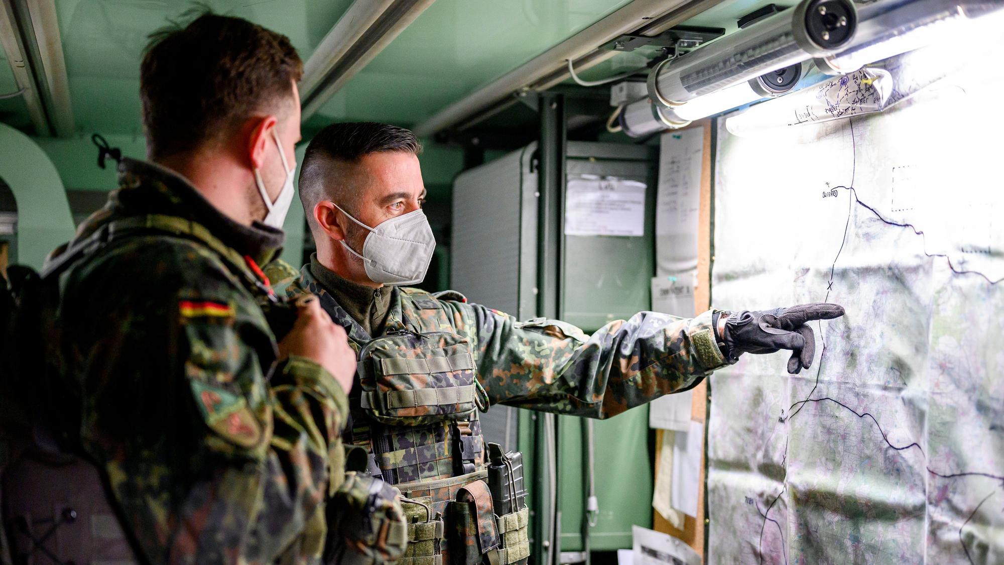 07.03.2022, Bayern, Wildflecken: Zwei Soldaten sichten eine Karte im Rahmen einer Übung eines simulierten Gefechts am Computer für die Nato-Einsatzgruppe im Gefechtssimulationszentrum des Heeres in Wildflecken (Landkreis Bad Kissingen).
