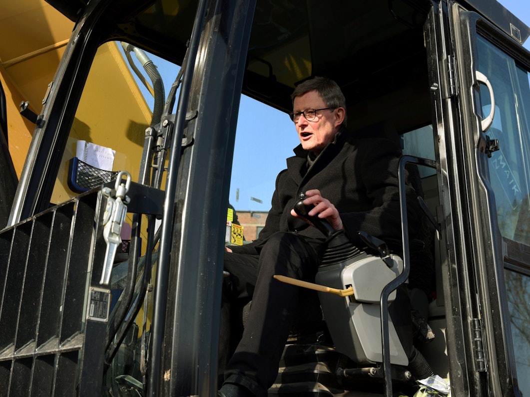 Kardinal Rainer Maria Woelki steuert bei seinem ersten Auftritt einen Bagger.