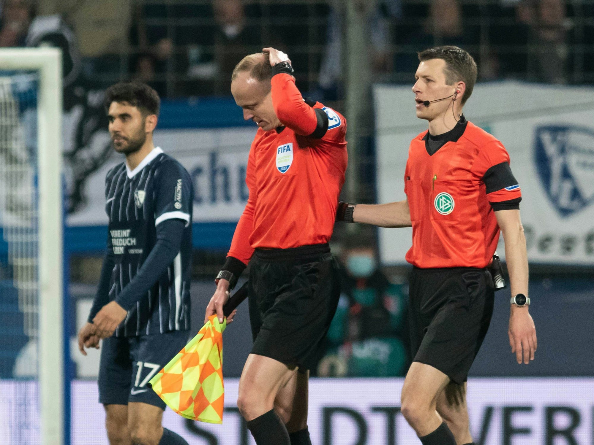 Das Schiedsrichtergespann um Benjamin Cortuns (r) verlässt während des Spiels das Spielfeld, nachdem Schiedsrichterassistent Christian Gittelmann (2.v.r.) einen Becher an den Kopf bekommen hatte.
