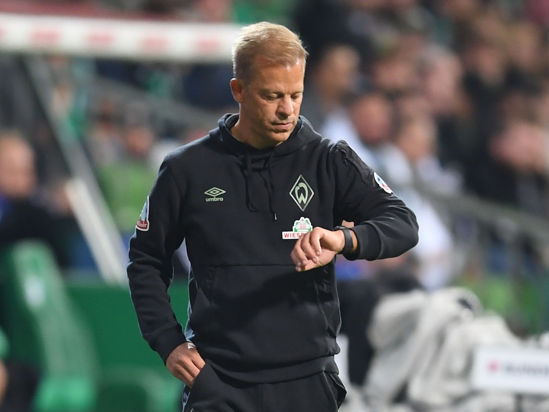 Werders ehemaliger Trainer Markus Anfang schaut an der Seitenlinie auf die Uhr.