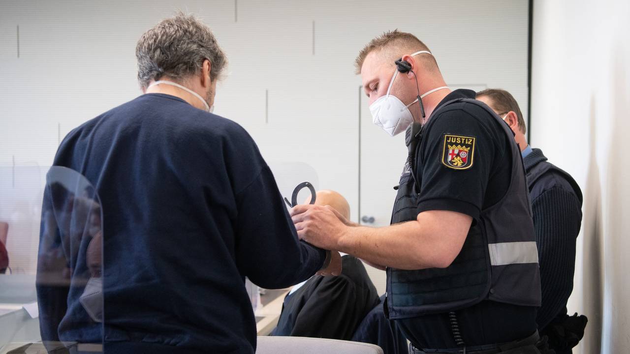 21.03.2022, Rheinland-Pfalz, Bad Kreuznach: Der Angeklagte wird in Handschellen in den Gerichtssaal gebracht. Der Mann soll im vergangenen Jahr in Bad Kreuznach den Mitarbeiter einer Tankstelle erschossen haben, nachdem dieser ihn auf die coronabedingte Maskenpflicht hingewiesen hatte.