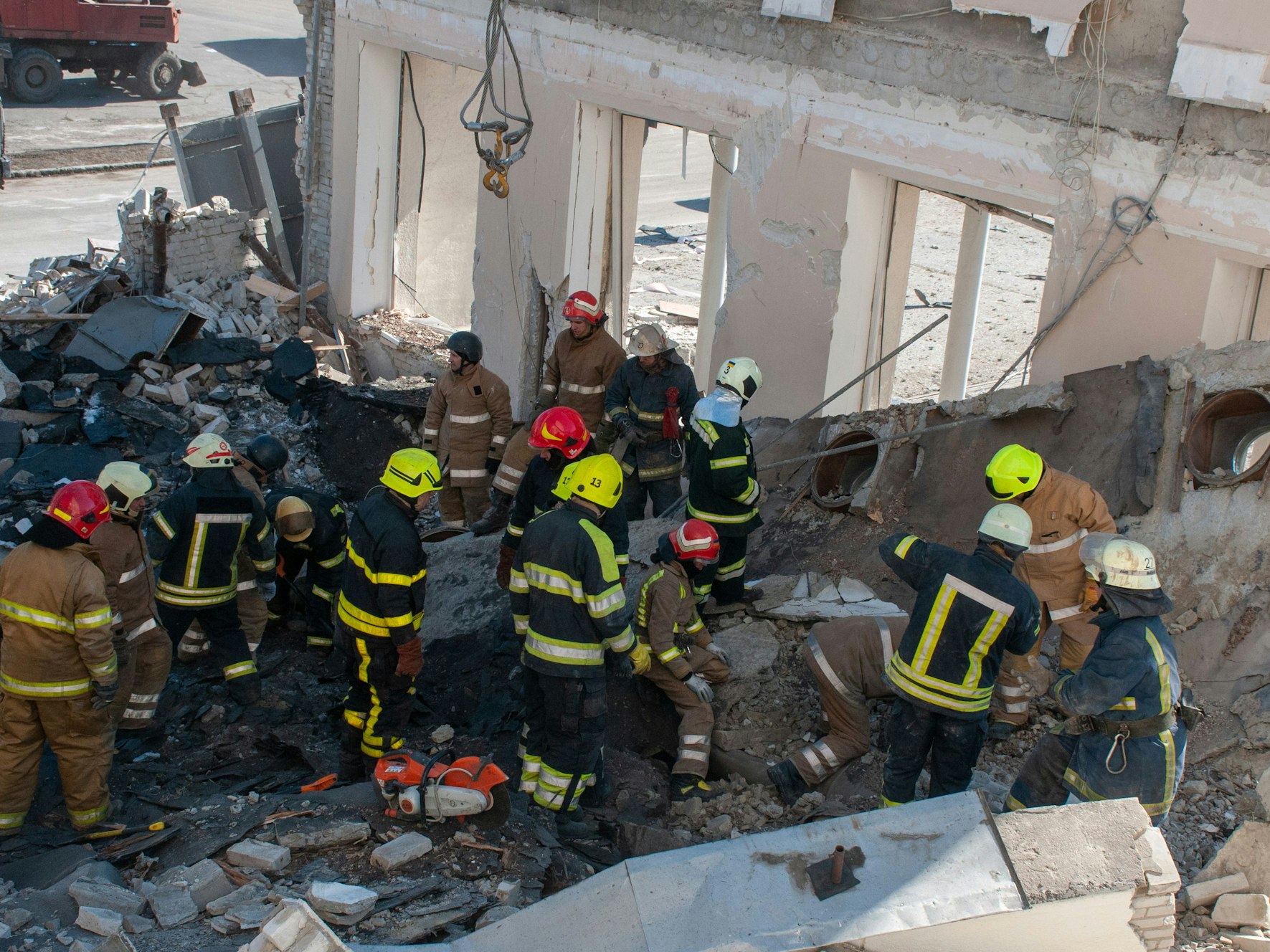 Rettungskräfte arbeiten inmitten von Trümmern eines zerstörten Gebäudes in Charkiw.