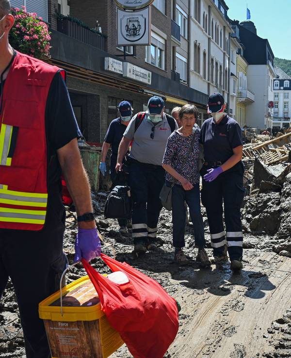 Das Foto vom 12.10.2021 zeigt Helfende der Johanniter in Bad Neuenahr-Ahrweiler, die eine Seniorin kurz nach der Flut-Katastrophe aus ihrer Wohnung begleiten.