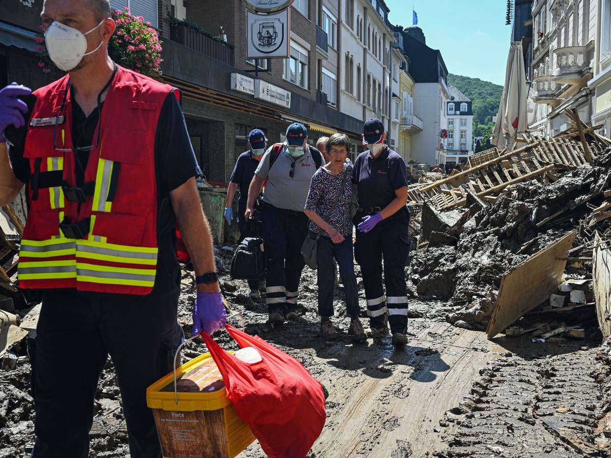 Das Foto vom 12.10.2021 zeigt Helfende der Johanniter in Bad Neuenahr-Ahrweiler, die eine Seniorin kurz nach der Flut-Katastrophe aus ihrer Wohnung begleiten.
