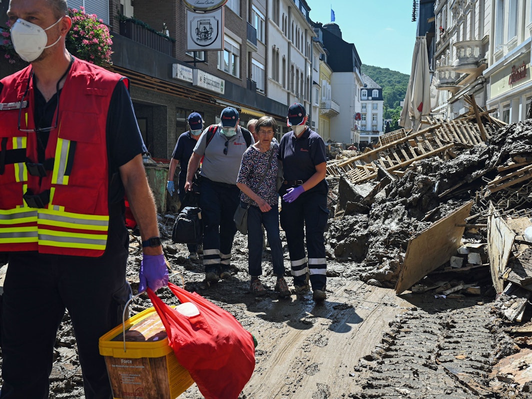 Das Foto vom 12.10.2021 zeigt Helfende der Johanniter in Bad Neuenahr-Ahrweiler, die eine Seniorin kurz nach der Flut-Katastrophe aus ihrer Wohnung begleiten.