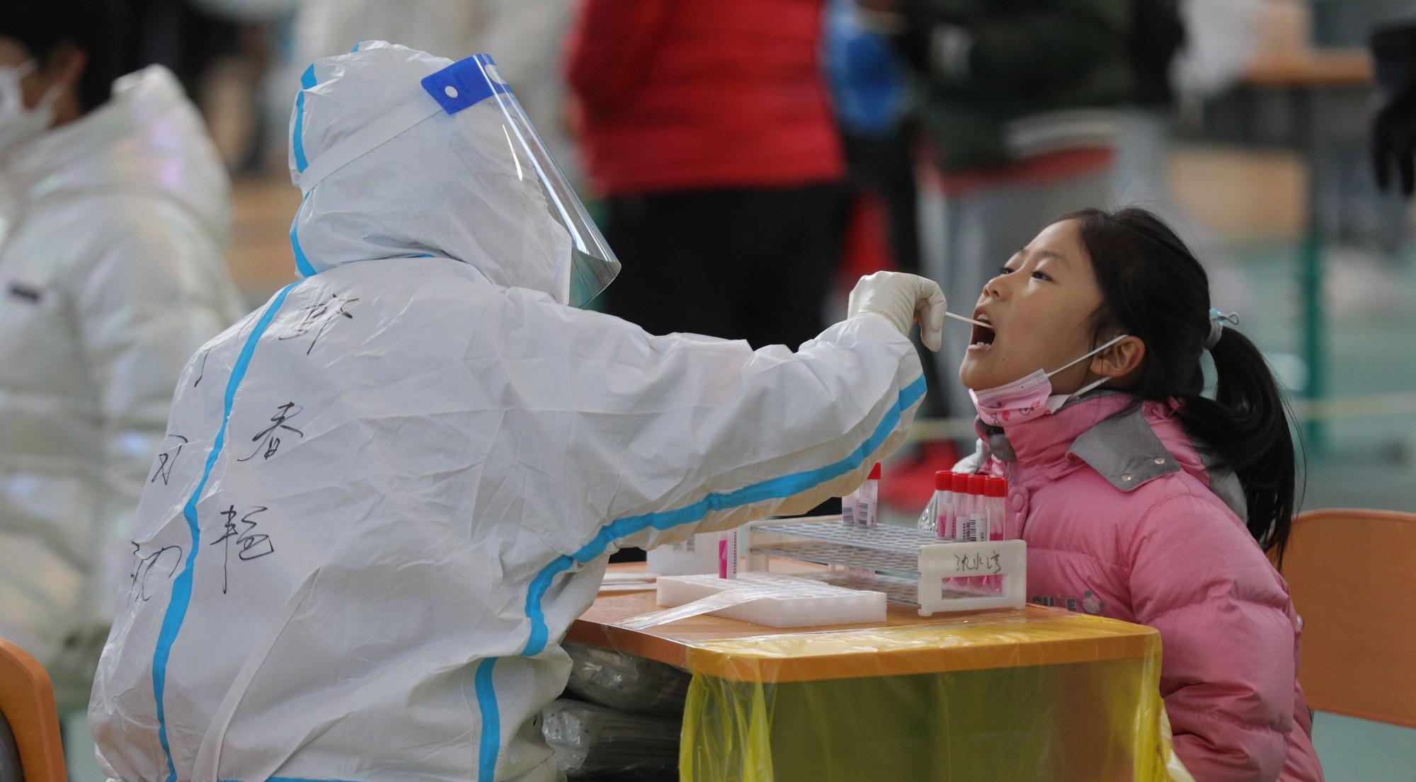 19.03.2022, China, Shenyang: Einem Mädchen in Shenyang in der nordostchinesischen Provinz Liaoning wird eine Abstrichprobe für einen Nukleinsäuretest entnommen.