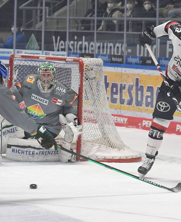Sebastian Uvira (Kölner Haie, r.) spielt den Puck in Augsburg.