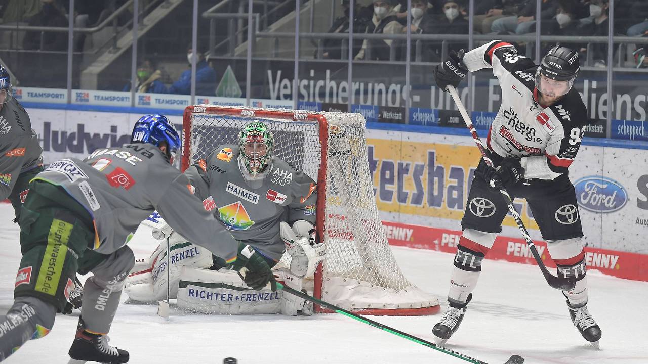Sebastian Uvira (Kölner Haie, r.) spielt den Puck in Augsburg.