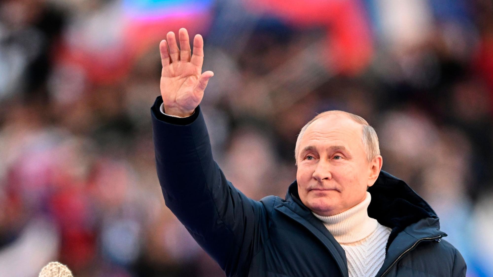 18.03.2022, Russland, Moskau: Das von der staatlichen russischen Nachrichtenagentur Sputnik durch AP veröffentlichte Poolbild zeigt Wladimir Putin, Präsident von Russland, der die Teilnehmer des Konzerts zum achten Jahrestag des Referendums über den Status der Krim und Sewastopols und deren Wiedervereinigung mit Russland begrüßt.