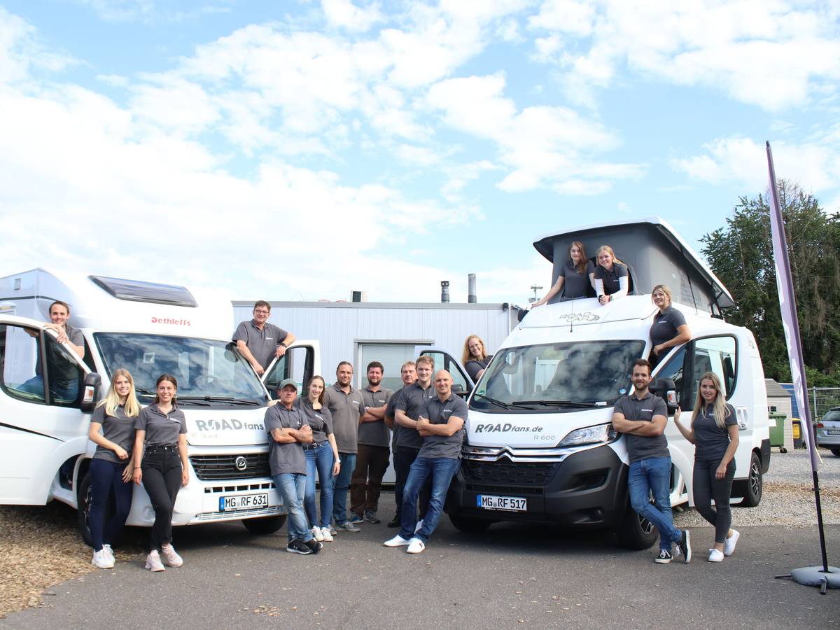 Das Team von roadfans steht vor zwei ihrer Fahrzeuge.